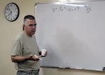 Spc. Doug Lane, an intelligence analyst with Headquarters and Headquarters Company, 110th Combat Sustainment Support Battalion, 224th Sustainment Brigade, 103rd Sustainment Command (Expeditionary), explains an algebraic equation to his math class at the COB Adder Education Centeron Contingency Operating Base Adder, Iraq, Sept. 19, 2010.