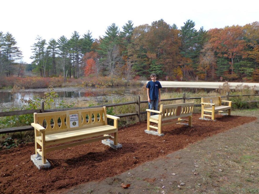 Boy Scout Jacob Piotrowski stands near his completed military memorial bench project at West Hill Dam, Uxbridge, Massachusetts.