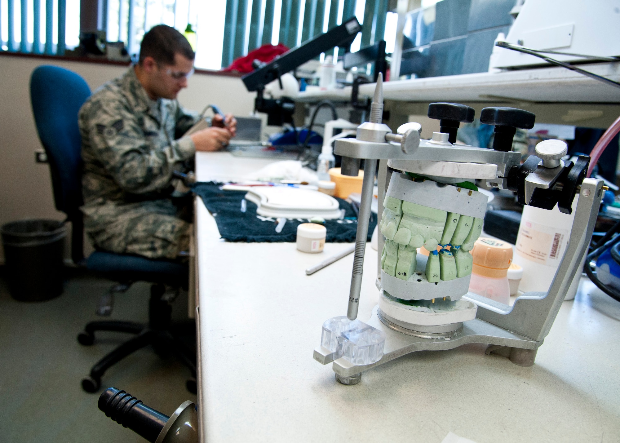 Senior Airman Jonathon Stambaugh, a 21st Dental Squadron dental lab technician, uses a mold to create porcelain teeth at the Area Dental Lab April 8, 2015, on Peterson Air Force Base, Colo. The ADL is one of three Defense Department labs that provide fixed dental works along with removable dental works and services DOD bases around the world. (U.S. Air Force photo/Senior Airman Tiffany DeNault)