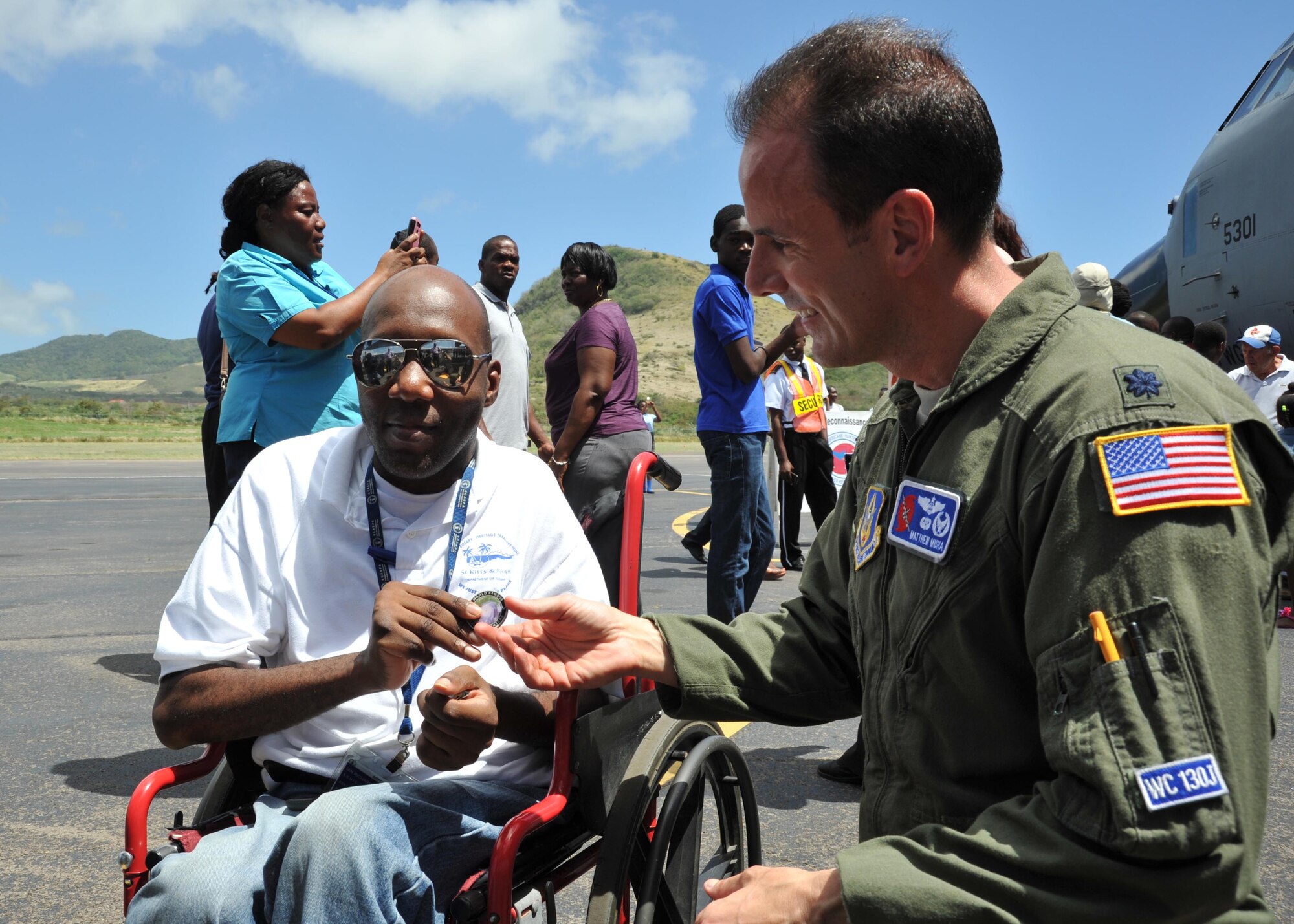 Lt. Col. Matthew Muha, 53rd Weather Reconnaissance Squadron commander, presents Ian Richards, who works for the Government Information Service office for St Kitts and Nevis, a Hurricane Hunter coin recognizing him for his excellent service April 24, 2015, during the Caribbean Hurricane Awareness Tour. The outreach program, which began in the 1970's and is a joint effort between National Oceanic and Atmospheric Administration's National Hurricane Center and the 403rd Wing's 53rd Weather Reconnaissance Squadron, promotes hurricane awareness and preparedness throughout the Caribbean region. (U.S. Air Force photo/Maj. Marnee A.C. Losurdo)
