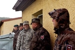 Army Staff Sgt. Paul Bianchi, a driver and gunner with the Colorado Army National Guard's Operational Mentor and Liaison Team-Augmentation and formerly an infantryman with the scout platoon of COARNG's Headquarters and Headquarters Company, 1st Battalion, 157th Infantry, waits for formation outside his barracks with some Slovenian soldiers who he has been training with at U.S. Army Garrison Hohenfels in Germany, Sept. 3, 2010. The OMLT-A spent five weeks training at Hohenfels in order to fulfill its Joint Mission Readiness Center requirements in preparation for its deployment to Afghanistan in October.