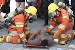 Thai firefighters respond to simulated personnel injuries during emergency response exercises held at the Port of Bangkok, Thailand.