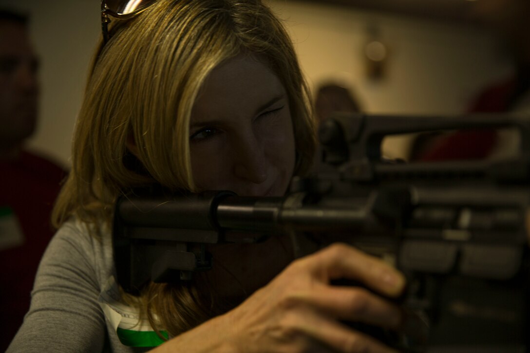 Karen Venema, a military spouse and native of Visalia, Calif., practices her M4 rifle technique during the II Marine Headquarters Group spouses event titled “In Their Boots,”  more commonly known as Jane Wayne Day, aboard Camp Lejeune, N.C., April, 17, 2015. The event included hands-on practice at the Indoor Simulated Marksmanship Trainer and Combat Convoy Simulators, and aims to build cohesion and shed light on military training within the II MHG families. (U.S. Marine Corps photo by Lance Cpl. Fatmeh Saad/Released)