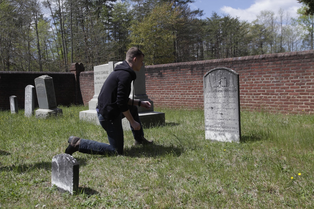 Cpl. Joseph Kotara kneels in front of a headstone in the Chancellorsville family cemetery during a tour of the Chancellorsville Battlefield in Virginia April 23, 2015. Kotara is an administrative specialist with Headquarters and Headquarters Squadron at Marine Corps Air Station Cherry Point, North Carolina.