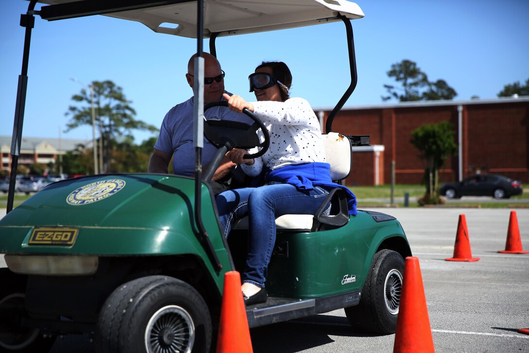 Dough Coley, left, supervises Lance Cpl. Zhenya Mcnabb as she maneuvers through traffic cones during the beer goggles interactive event at Marine Corps Air Station Cherry Point, North Carolina, April 24, 2015. Marines wore vision impairing goggles that simulated the effects of alcohol on their ability to perform basic tasks. Coley is a state trooper with the North Carolina State Troopers and Mcnabb is an administrative specialist with Headquarters and Headquarters Squadron.