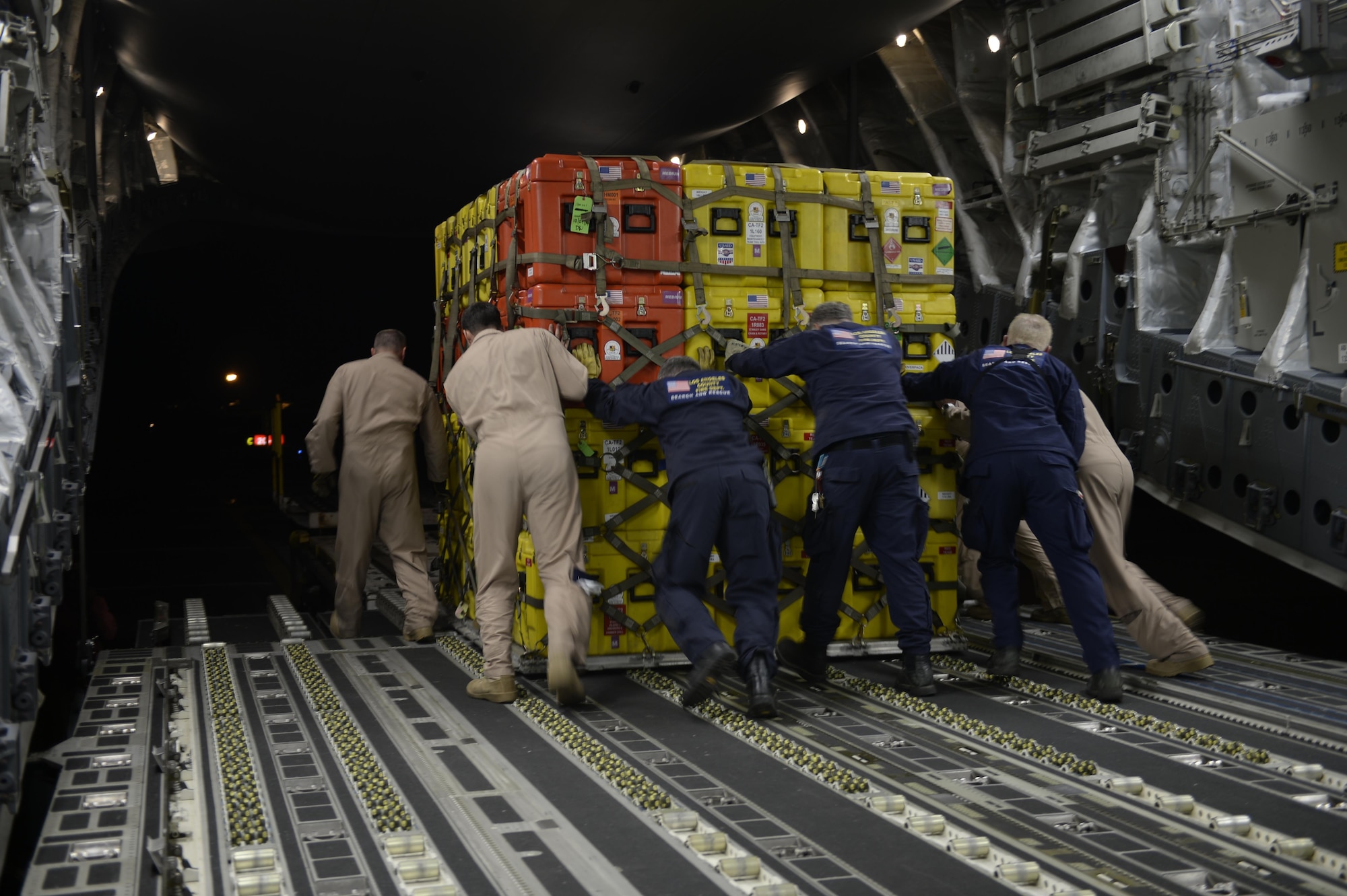 U.S. Air Force Airmen and members of the United States Agency to International Development (USAID) and Los Angeles County Search and Rescue team offload relief supplies for victims of the earthquake in Katmandu, Nepal, April 28, 2015. The Air Force transported relief supplies along with members of the United States Agency to International Development (USAID), the Los Angeles County Search and Rescue team and five search and rescue dogs to provide assistance to the men and women in Nepal. (U.S. Air Force photo/Airman 1st Class Taylor Queen)