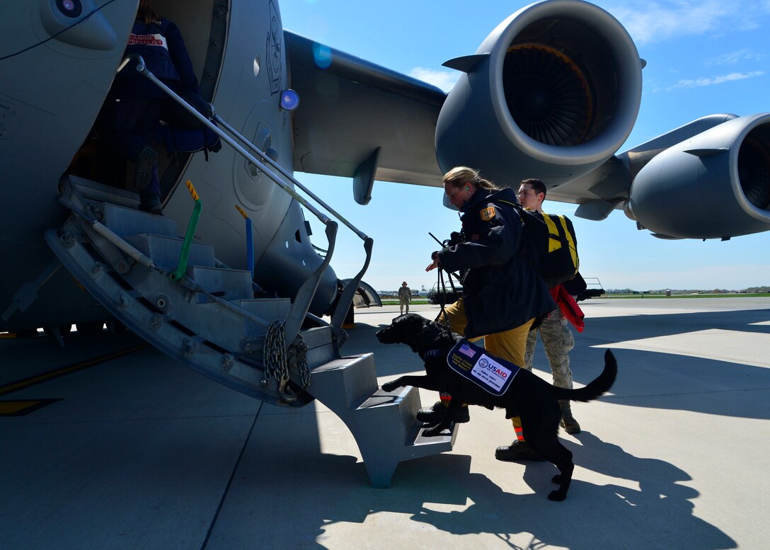 Jennifer Massey, Fairfax County Urban Search and Rescue K-9 search specialist, Fairfax, Va., and her K-9, Phayu, board a U.S. Air Force C-17 Globemaster III at Dover Air Force Base, Del., April 26, 2015. Massey and Phayu are part of a 69-person search and rescue team deploying to Nepal to assist in rescue operations after the country was struck by a 7.8-magnitude earthquake. (U.S. Air Force photo/Airman 1st Class William Johnson)