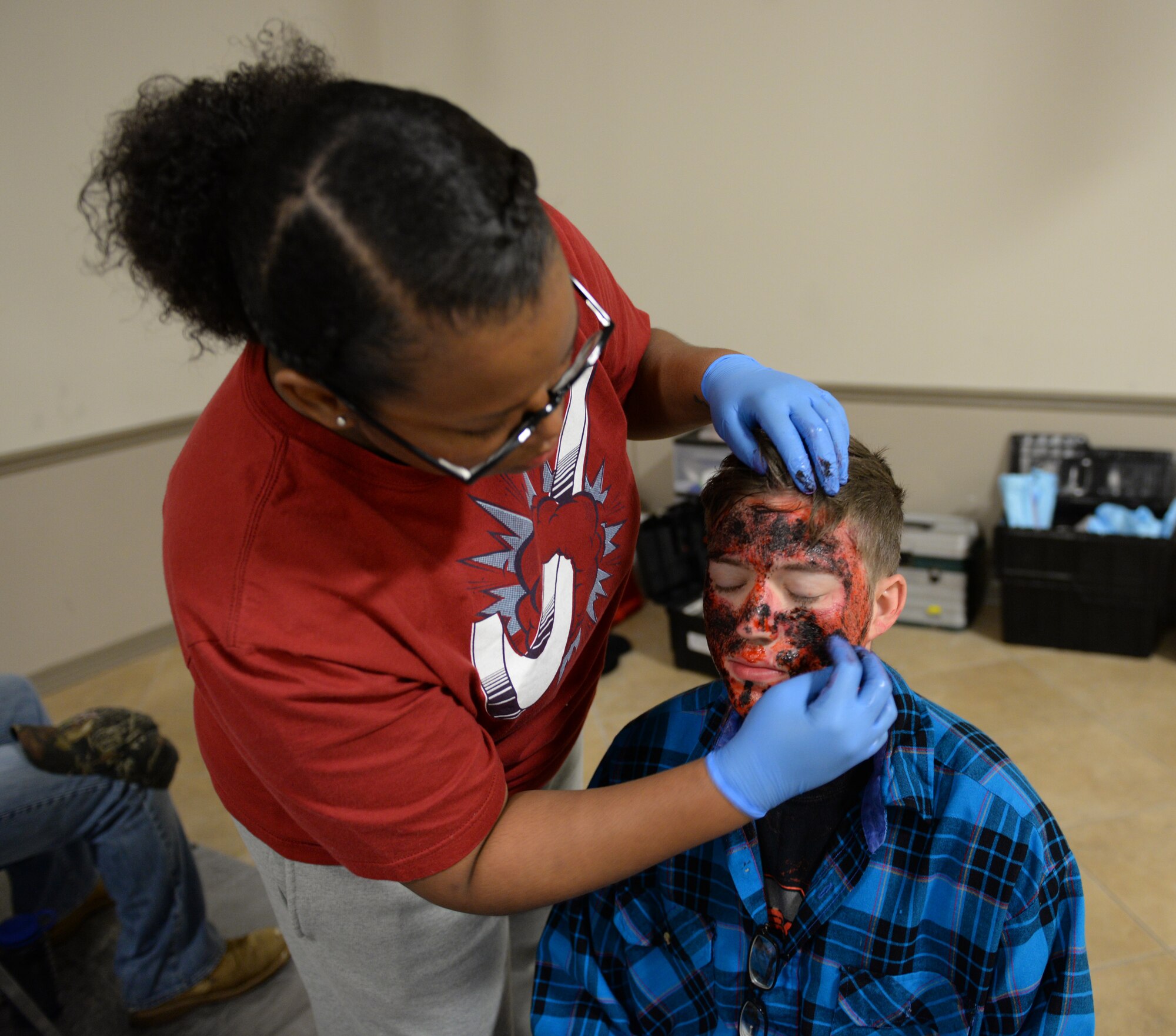 A member of Team Barksdale expert applies make-up on an Airman who volunteered to be a simulated casualty for a Major Accident Response Exercise on Barksdale Air Force Base, Louisiana, April 28, 2015. More than 50 members of Team Barksdale volunteered to be simulated victims and casualties for the MARE by assisting wing inspection team members in evaluating how medical, security forces and emergency services agencies responded to the incident. (U.S. Air Force photo/Airman 1st Class Curt Beach)