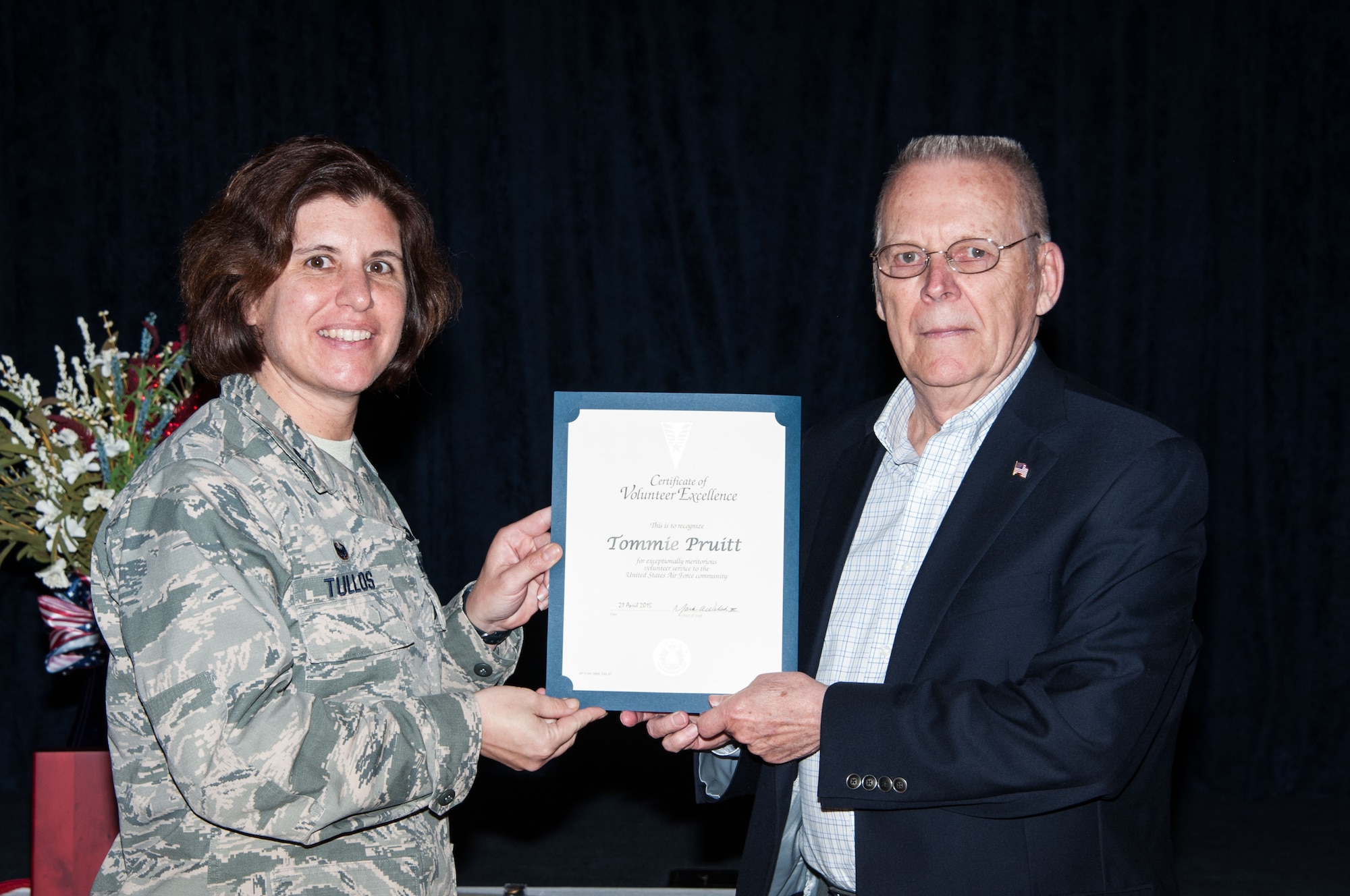 Col. Andrea Tullos, 42nd Air Base Wing commander, presents the Volunteer Excellence Award to retired Chief Master Sgt. Tommie Pruitt. Pruitt has been volunteering at the Gunter pharmacy for 15 years, clocking in about 500 hours a year. (U.S. Air Force photo by Henry Hancock/Cleared)