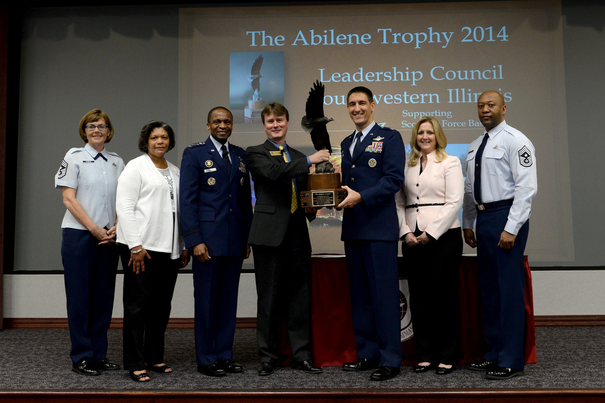 The Southwestern Illinois area was presented the coveted Abilene Trophy April 17 for the second time in the last three years in recognition of the extensive support demonstrated during 2014 for Scott Air Force Base’s military members and their families. Left to Right: Air Mobility Command Command Chief CMSgt Victoria Gamble, Mrs. Evelyn McDew, Air Mobility Command Commander Gen. Darren McDew, Chair of the Military Affairs Committee for the Abilene Chamber Gray Bridwell, Installation Commander and Commander 375th Air Mobility Wing Col. Kyle Kremer, Mrs. Deb Kremer, and 375th Air Mobility Wing Command Chief CMSgt Wes Mathias. (U.S. Air Force photo Senior Airman Tristin English)