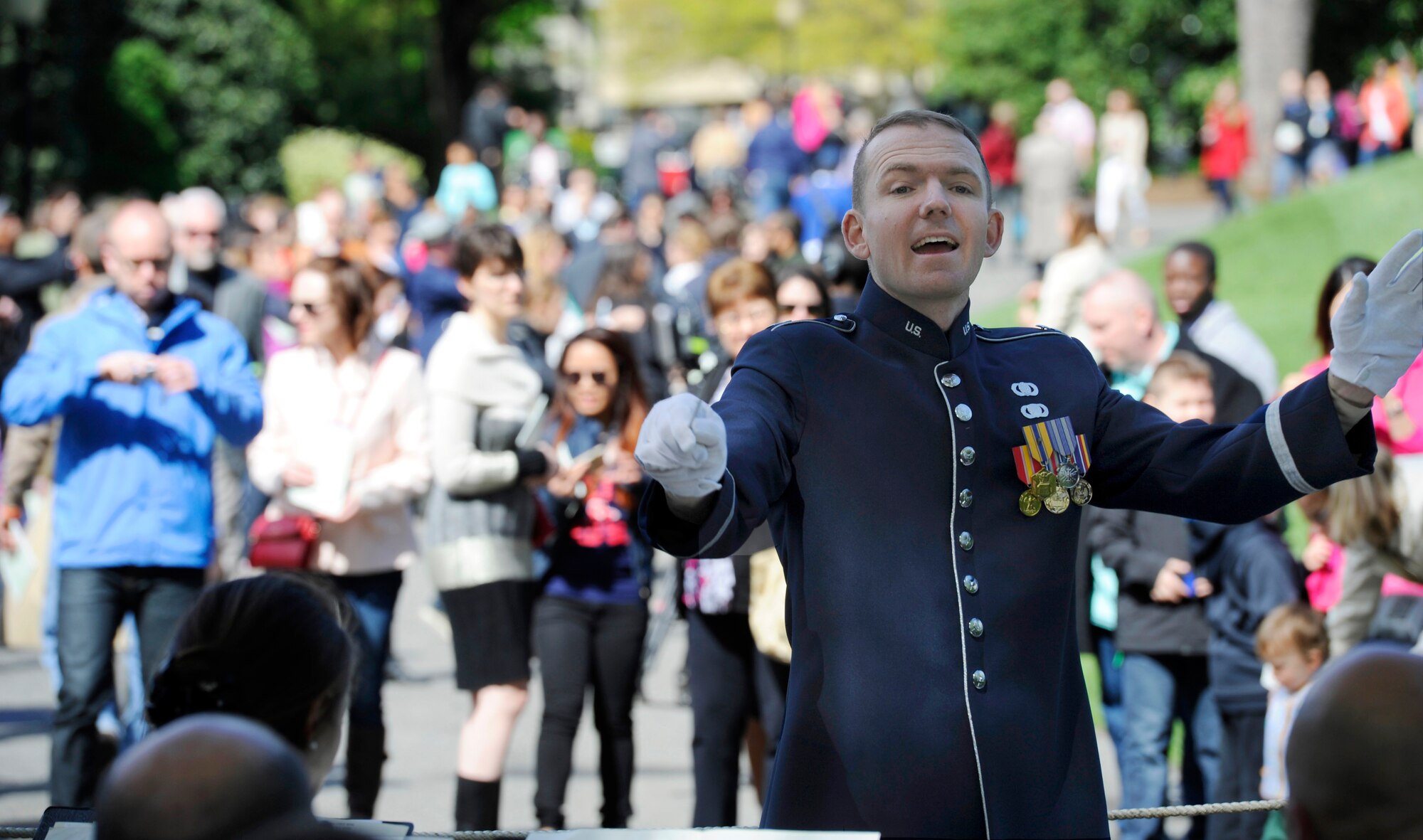 Capt. Joseph Hansen, U.S. Air Force Concert Band conductor and flight commander, leads the band during a White House Garden Tour Concert in Washington, D.C., April 26, 2015. Visitors gathered to listen music during a tour of the South Lawn and gardens of the White House.(U.S. Air Force photo/Airman 1st Class Ryan J. Sonnier)