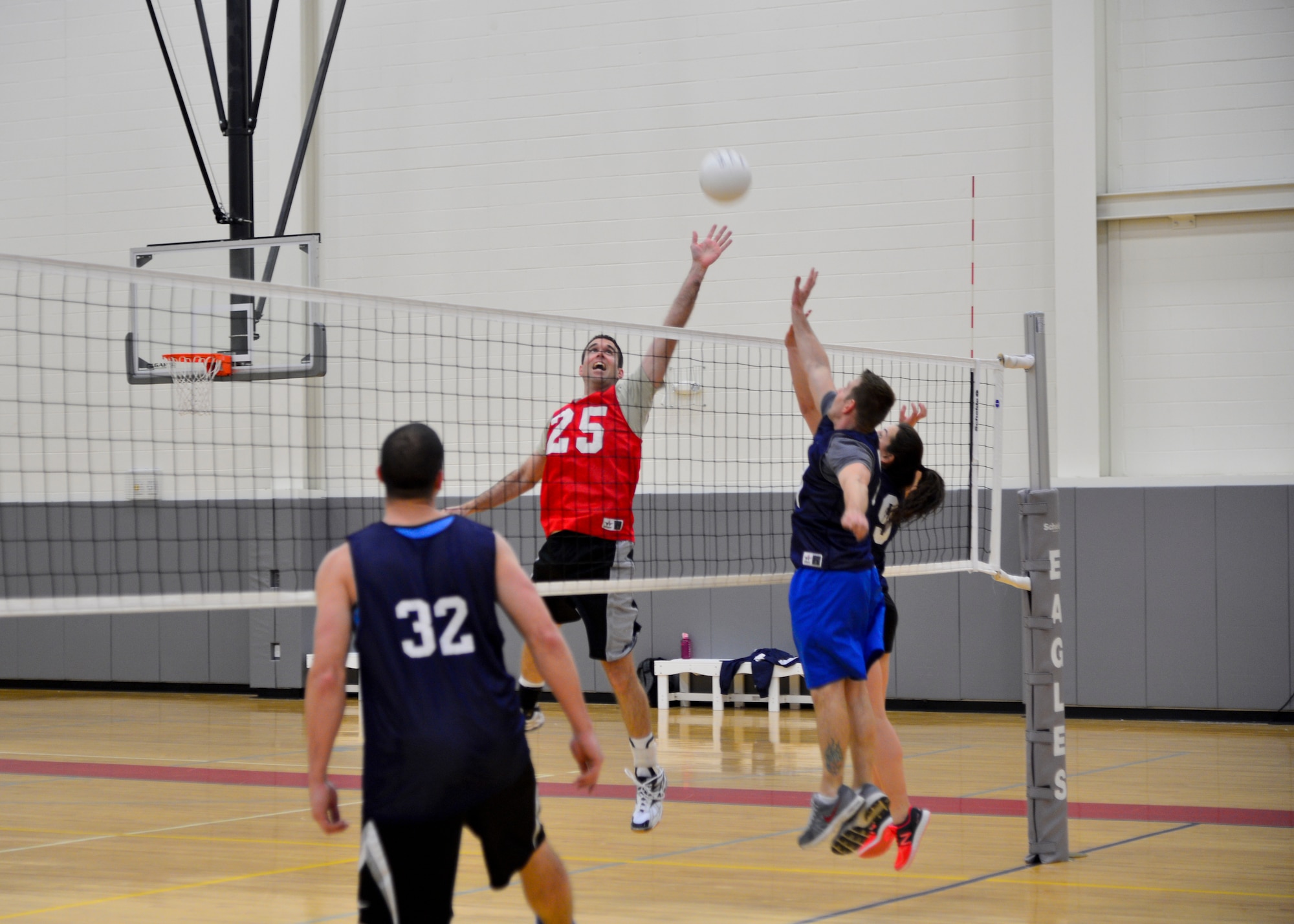 Scott Saffran, 3d Airlift Squadron/436th Operations Support Squadron, tips a volleyball over two 9th Airlift Squadron defenders during an intramural volleyball game April 23, 2015, at the fitness center on Dover Air Force Base, Del. The 3d AS/436th OSS suffered their sixth loss of the season and was swept by the 9th AS 25-18 and 25-23. (U.S. Air Force photo/Airman 1st Class William Johnson)