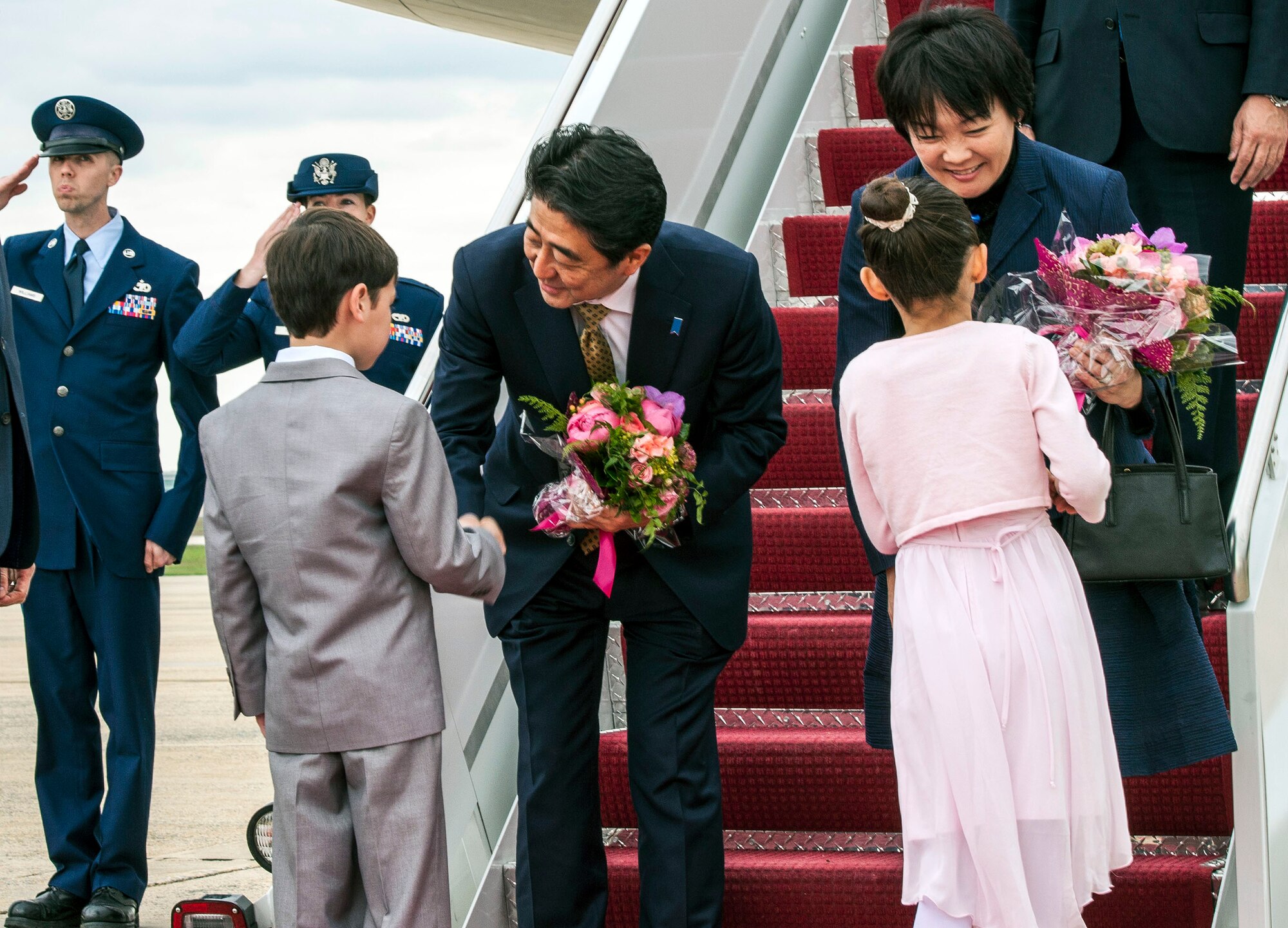 Shinzō Abe, Japanese Prime Minister, and his wife, Akie Abe, greet and receive flowers from Glenn Vamvalnburg, Great Falls Elementary School 2nd grader, and Megan Dooley, 4th grade Junior Olympic gymnast, at Joint Base Andrews, Md., April 27, 2015. Abe is in the U.S. for a week-long visit to promote stronger military and economic ties. (U.S. Air Force photo by Senior Master Sgt. Kevin Wallace/RELEASED)