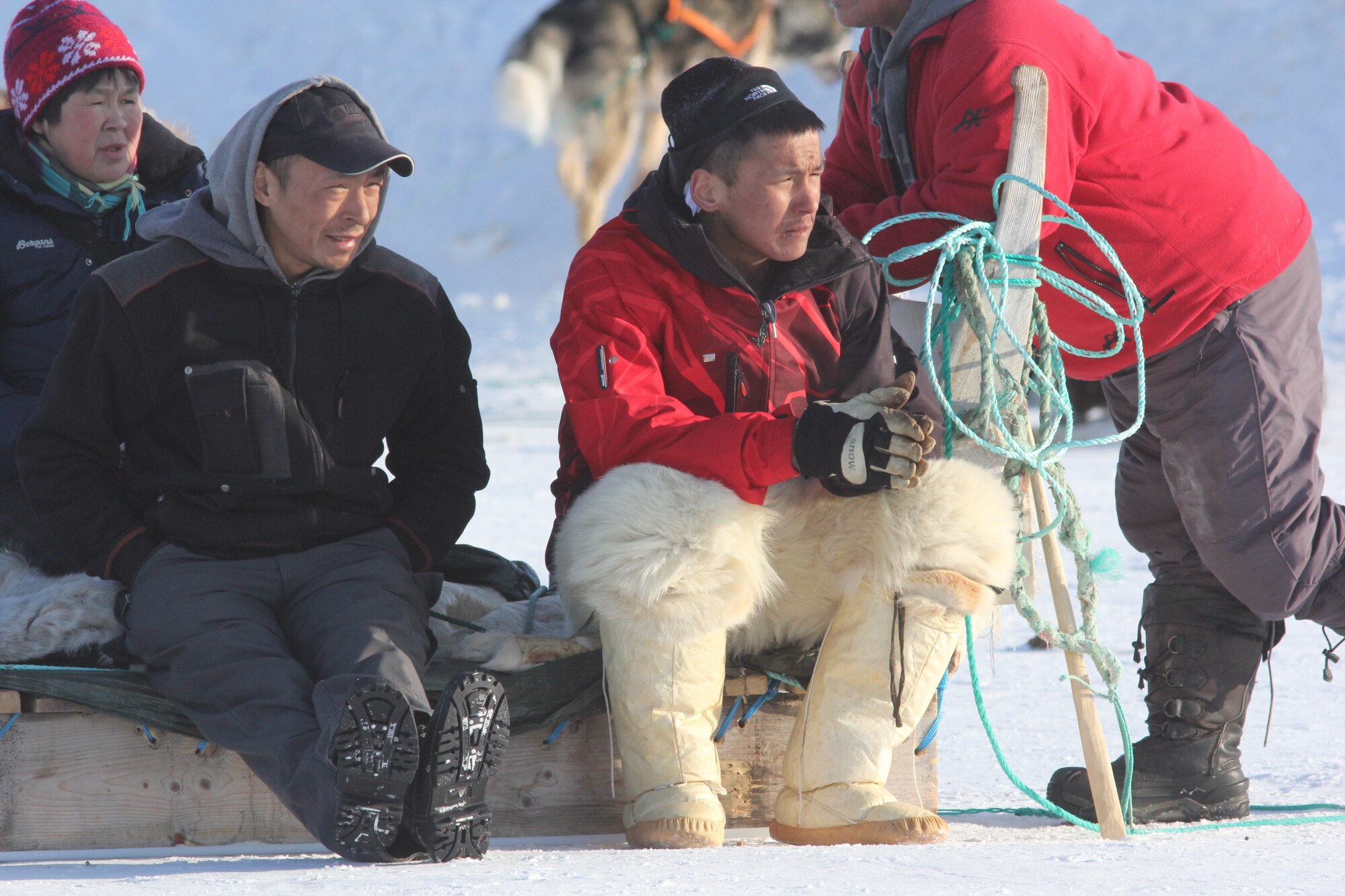 THULE AIR BASE, Greenland – Greenlandic visitors watch the dogsled races during the Thule Armed Forces Day event, April 5, 2015. Armed Forces Day is an annual event where Thule AB opens its gates to promote interaction and a cultural learning experience with local Greenlandic villagers through dogsled races, craft sales, a buffet at the Top of the World Club and a chance for a ride in an Air Greenland helicopter. (U.S. Air Force by 1st Lt. Alexandra Swanson)  
