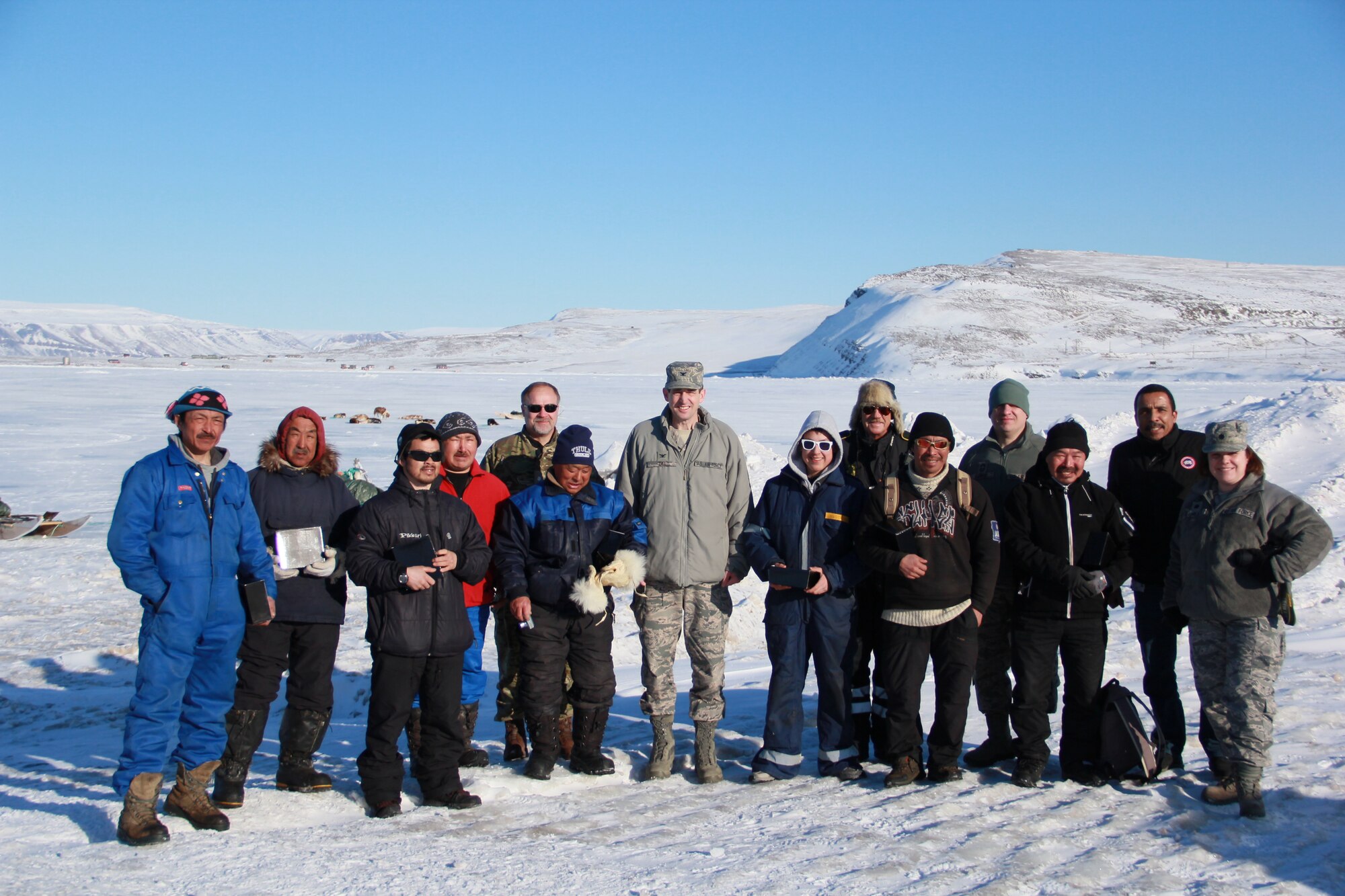 THULE AIR BASE, Greenland – Col. Todd Diel, 821st Air Base Group commander, Lt. Col. Stacy Clements, 821st ABG deputy commander, Chief Master Sgt. Michael Garrou, 821st ABG superintendent, and other members of Team Thule meet with Greenlandic dogsled teams during the Thule Armed Forces Day celebration April 5, 2015. Armed Forces Day is an annual event where Thule AB opens its gates to promote interaction and a cultural learning experience with local Greenlandic villagers through dogsled races, craft sales, a buffet at the Top of the World Club and a chance for a ride in an Air Greenland helicopter. (U.S. Air Force by 1st Lt. Alexandra Swanson)