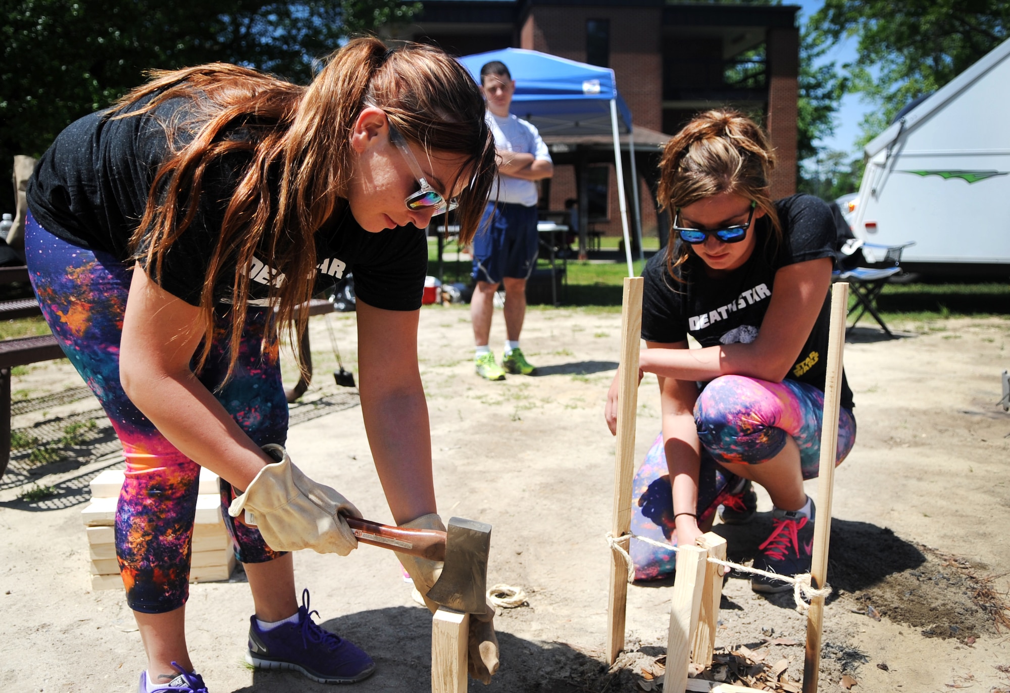 A team of “Community Quest” competitors, “The Force,” splits wood and makes other preparations to start a fire during a Club Day event, April 24, 2015, at Seymour Johnson Air Force Base, North Carolina. The quest featured 11 stops with mental and physical challenges that took two-person teams across the base, including the base library, flight kitchen and bowling alley. (U.S. Air Force photo/Senior Airman Ashley J. Thum)