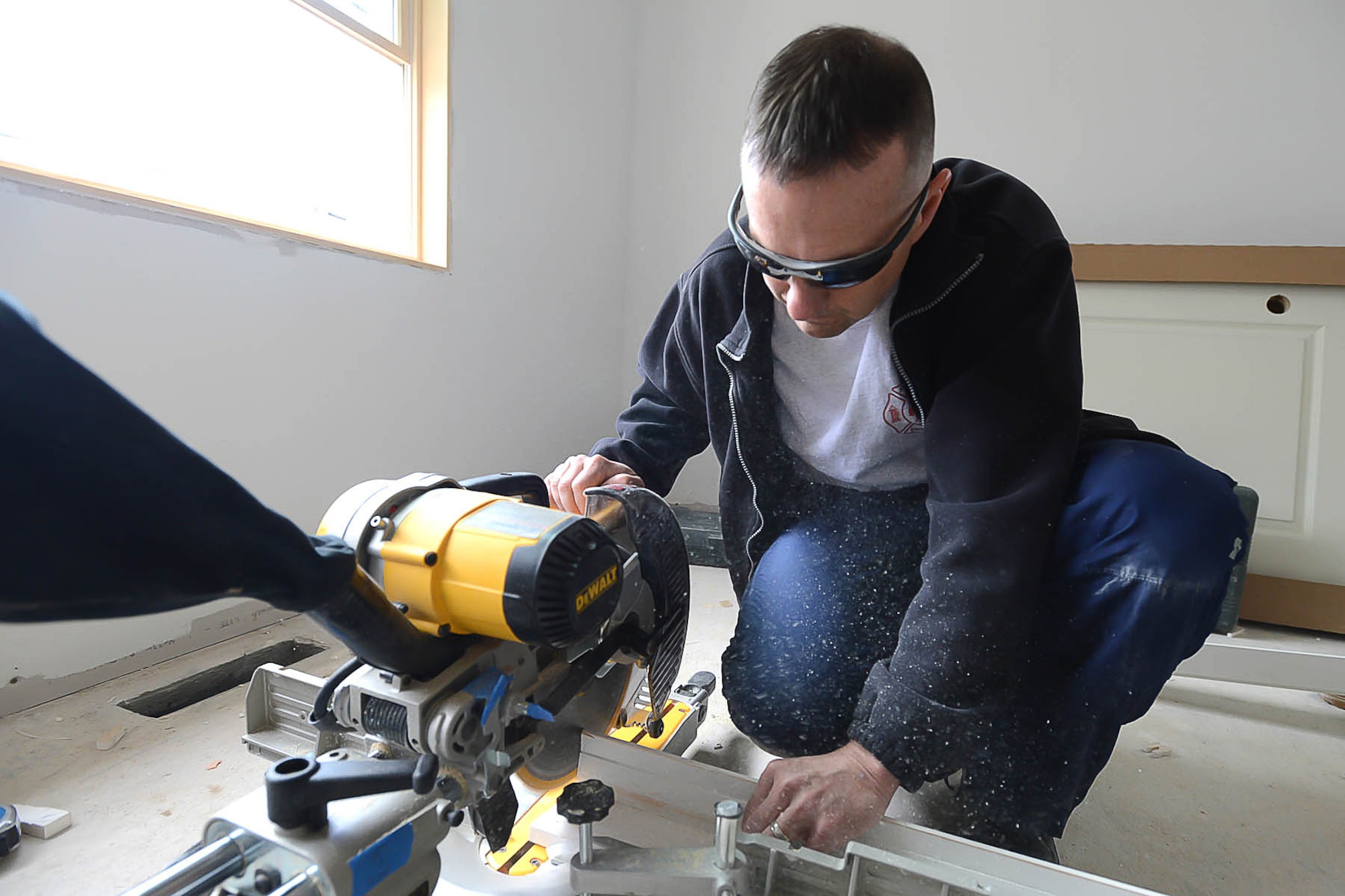 Hanscom Command Chief Master Sgt. Craig Poling uses a saw to trim a door frame prior to installation during a Habitat for Humanity home construction project April 23. Base volunteers participated in two community projects in Billerica, Mass., as part of a Patriot Enlisted Association-led volunteer project. (U.S. Air Force photo by Jerry Saslav)