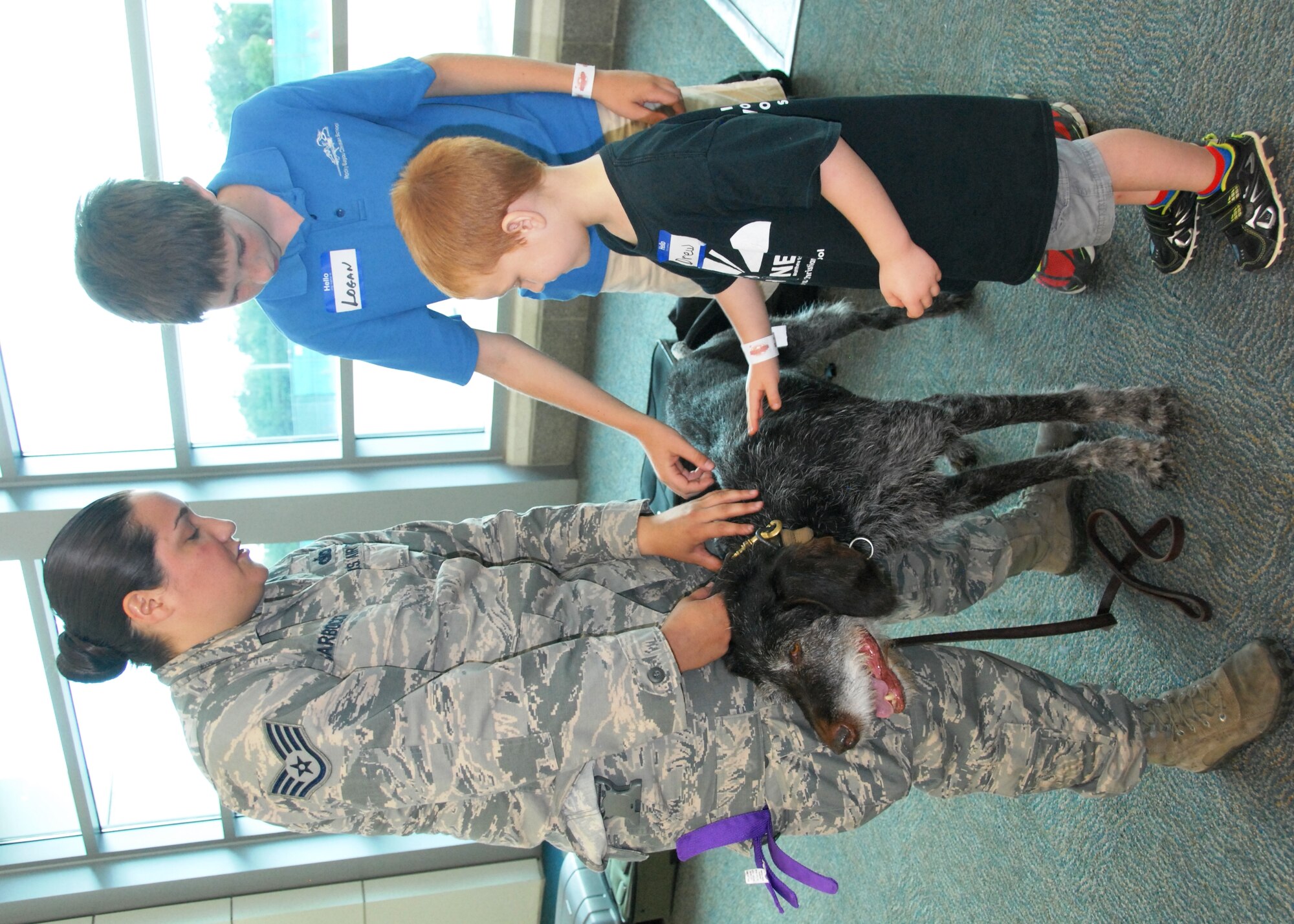 Staff Sgt. Tatiana Carbocci, a 96th Security Forces Squadron military working dog handler from Eglin Air Force Base, Fla., shows Logan Lieb and Drew Schnieder the proper way to approach Kanjer, following a K-9 explosives/narcotics detection demonstration at the “Take Our Daughters and Sons To Work Day” event April 23 at the Destin/Fort Walton Beach Airport.  Among the visuals SFS provided were: exploration of police cars and prohibited items static displays; an x-ray with prohibited items demonstration; and explosives detection systems and checked baggage explosive detection systems tours.  (U.S. Air Force photo/Kevin Gaddie)