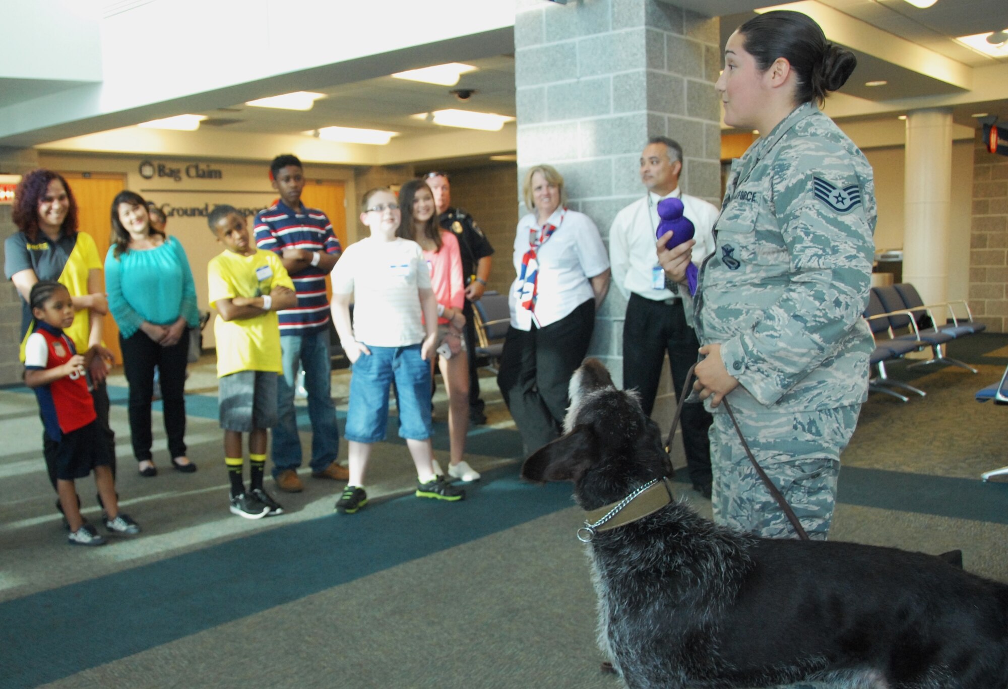 Staff Sgt. Tatiana Carbocci, a 96th Security Forces Squadron military working dog handler from Eglin Air Force Base, Fla., stands with Kanjer and explains the  K-9 explosives/narcotics detection demonstration sequences of events to children and parents, at the “Take Our Daughters and Sons To Work Day” event April 23 at the Destin/Fort Walton Beach airport.  Among the visuals SFS provided were: exploration of police cars and prohibited items static displays; an x-ray with prohibited items demonstration; and explosives detection systems and checked baggage explosive detection systems tours.  (U.S. Air Force photo/Kevin Gaddie)