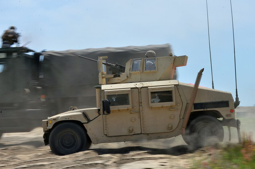 U.S. Marines assigned to the Marine Wing Support Squadron 273, Motor Transportation Company, Marine Corps Air Station Beaufort, S.C., drive a Humvee while fellow Marines provide cover during vehicle bounding training at Poinsett Electronic Combat Range, Wedgefield, S.C., April 23, 2015. During the convoy training, the Marines practiced responding to roadside bomb attacks, vehicle bounding, and vehicle extractions. (U.S. Air Force photo by Airman 1st Class Michael Cossaboom/Released) 