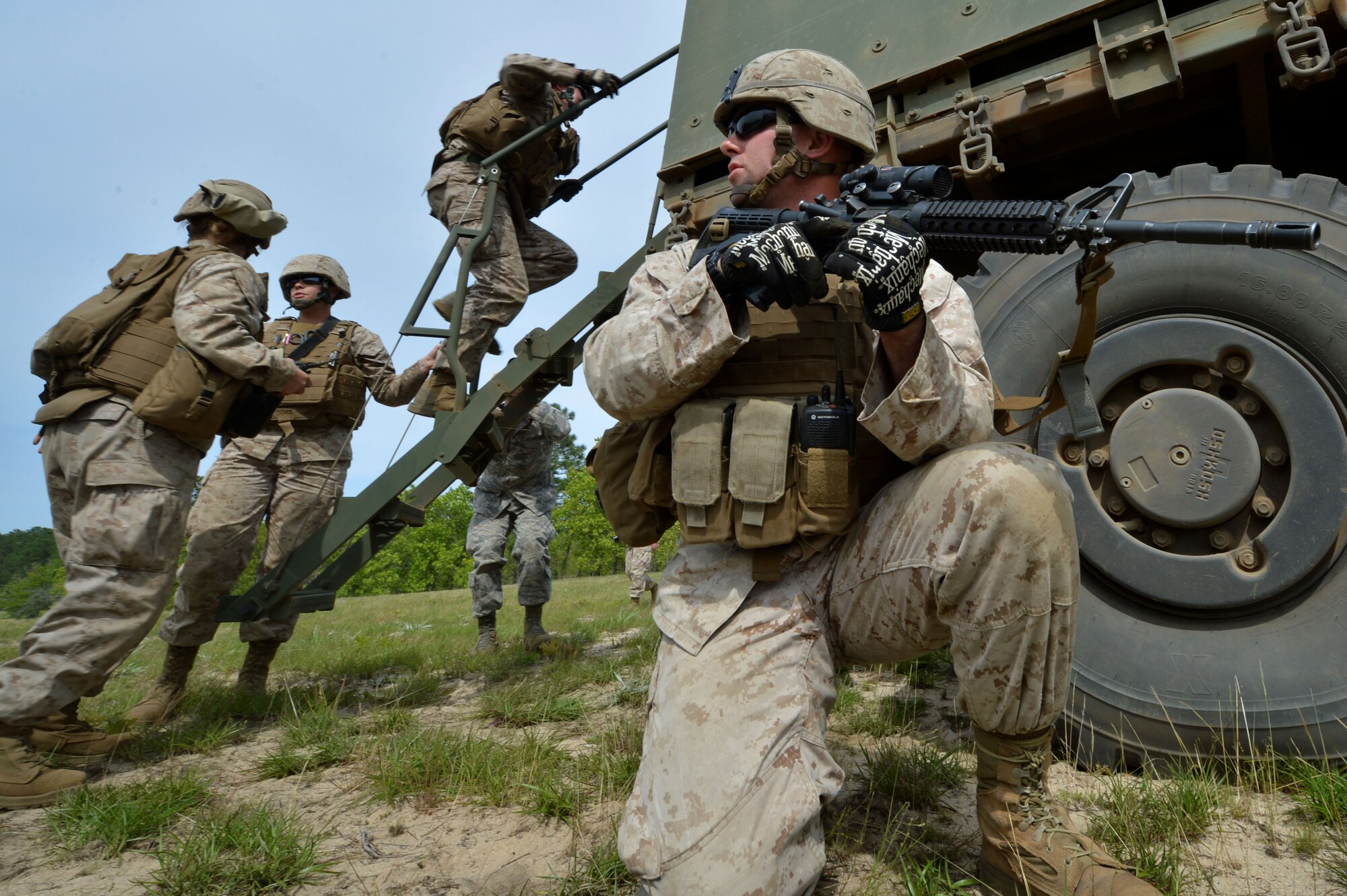 A U.S. Marine assigned to the Marine Wing Support Squadron 273, Motor Transportation Company, Marine Corps Air Station Beaufort, S.C., provides security while fellow Marines load a Marine with simulated injuries into a vehicle during roadside bomb training at Poinsett Electronic Combat Range, Wedgefield, S.C., April 23, 2015. The Marines spent five days at Poinsett to practice convoy skills, shooting, and teamwork. (U.S. Air Force photo by Airman 1st Class Michael Cossaboom/Released)