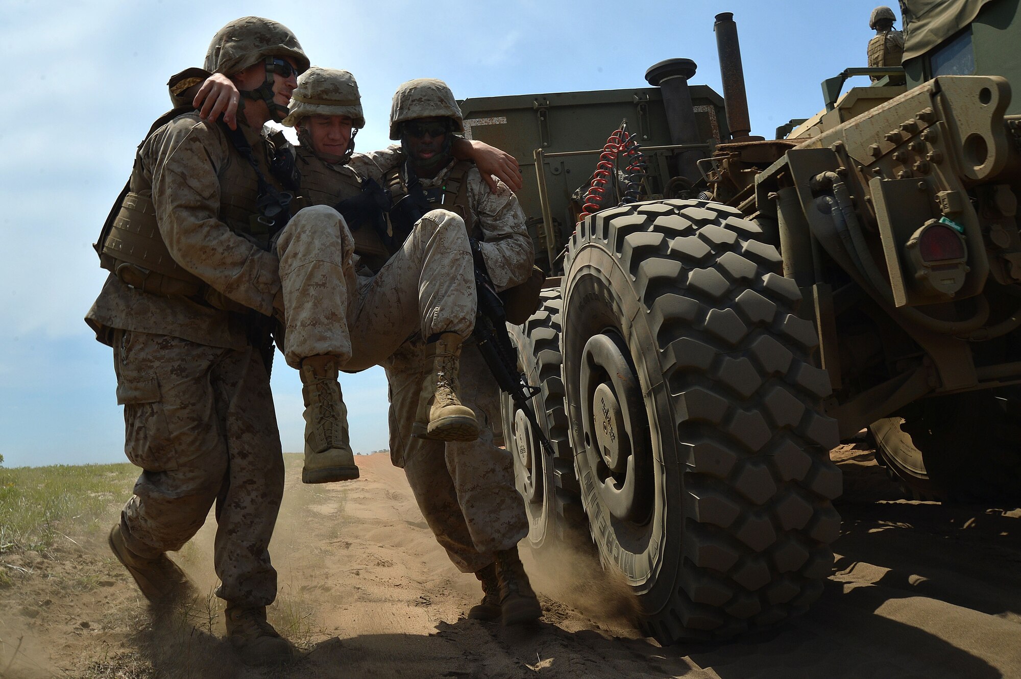 During roadside bomb training at Poinsett Electronic Combat Range, Wedgefield, S.C., U.S. Marines assigned to Marine Wing Support Squadron 273, Motor Transportation Company, Marine Corps Air Station Beaufort, S.C., carry a Marine with simulated injuries out of a vehicle, April 23, 2015. During this drill Marines worked together to save injured Marines and tow their vehicle away. (U.S. Air Force photo by Airman 1st Class Michael Cossaboom/Released)
