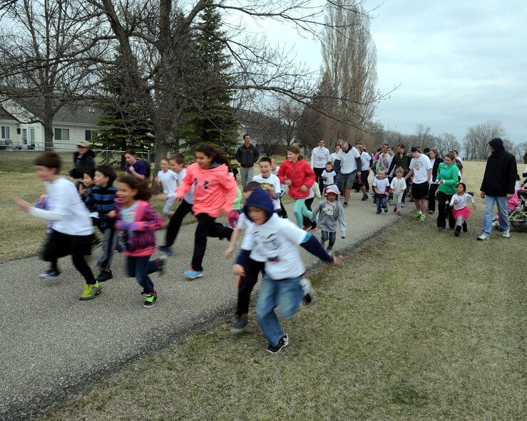 Children from the Nathan Twining Elementary/Middle School, take off during the Purple Up! fun run to and from Eielson Elementary school on April 24, 2015, on Grand Forks Air Force Base, N.D. Students, siblings and parents participated in the event in support of the Month of the Military Child. (U.S. Air Force Photo by Senior Airman Zachiah Roberson/Released)