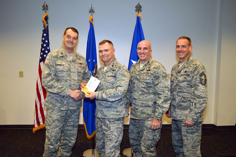 Brig. Gen. Kory Cornum, Air Mobility Command surgeon, presents the U.S. Air Force 2014 Clinical Excellence in Nursing Award to Maj. Marion Foreman Jr., 43rd Aeromedical Evacuation Squadron, with Col. Kenneth Moss, 43rd Airlift Group commander and Chief Master Sgt. James Cope, 43rd Airlift Group superintendent, during Cornum’s visit to the 43rd Airlift Group on Apr. 22, Pope Army Airfield, N.C. (U.S. Air Force photo/Marvin Krause)