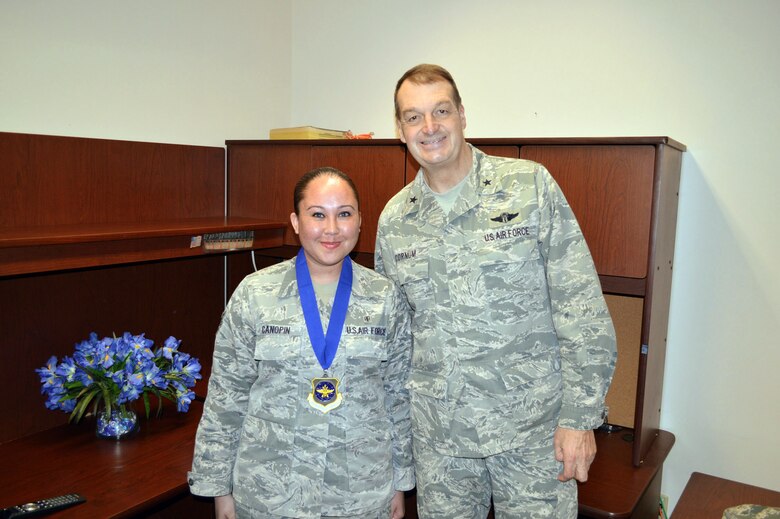 Brig. Gen. Kory Cornum, Air Mobility Command surgeon, presents the Air Mobility Command ‘Real Pro’ Award to Staff Sgt. Krystal Canopin, 43rd Medical Squadron, recognizing Canopin ‘s outstanding duty performance during his visit to the 43rd Airlift Group on Apr. 22, Pope Army Airfield, N.C. (U.S. Air Force photo/Marvin Krause)