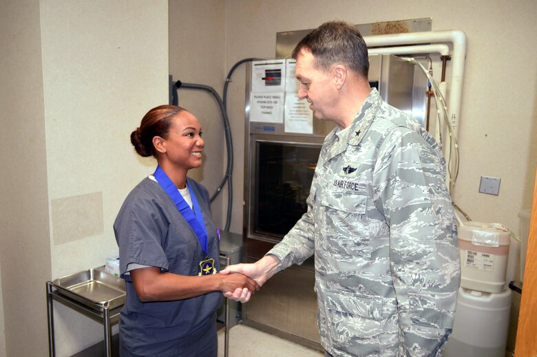 Brig. Gen. Kory Cornum, Air Mobility Command surgeon, presents the Air Mobility Command ‘Real Pro’ Award to Staff Sgt. Desiree Scarver, 43rd Medical Squadron, recognizing Scarver’s outstanding duty performance during his visit to the 43rd Airlift Group on Apr. 22, Pope Army Airfield, N.C. (U.S. Air Force photo/Marvin Krause)