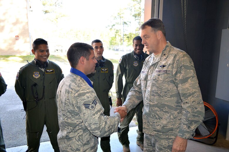 Brig. Gen. Kory Cornum, Air Mobility Command surgeon, presents the Air Mobility Command ‘Real Pro’ Award to Senior Airman Donald Souza, 43rd Aeromedical Evacuation Squadron, recognizing Souza’s outstanding duty performance during his visit to the 43rd Airlift Group on Apr. 22, Pope Army Airfield, N.C. (U.S. Air Force photo/Marvin Krause)