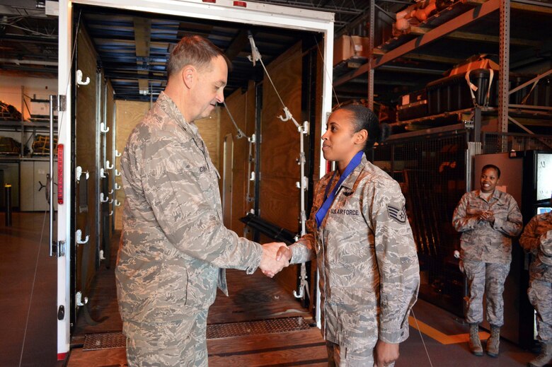 Brig. Gen. Kory Cornum, Air Mobility Command surgeon, presents the Air Mobility Command ‘Real Pro’ Award to Staff Sgt. Yaneesa Simpson, 43rd Aeromedical Evacuation Squadron, recognizing Simpson’s outstanding duty performance during his visit to the 43rd Airlift Group on Apr. 22, Pope Army Airfield, N.C. (U.S. Air Force photo/Marvin Krause)