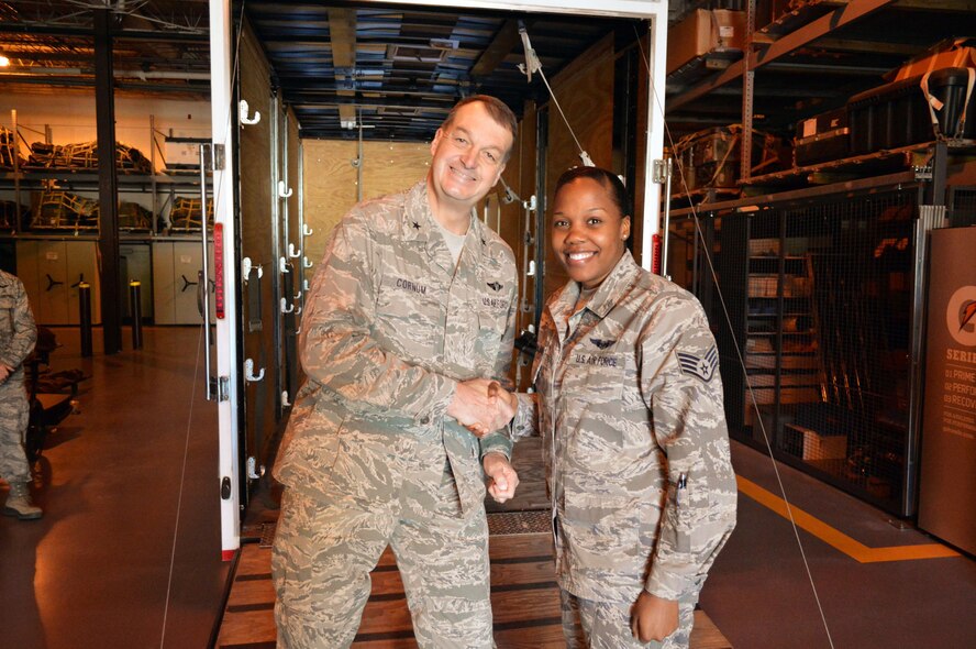 Brig. Gen. Kory Cornum, Air Mobility Command surgeon, presents his commander’s coin to Staff Sgt. Laquita Mason, 43rd Aeromedical Evacuation Squadron, recognizing Mason’s outstanding duty performance during his visit to the 43rd Airlift Group on Apr. 22, Pope Army Airfield, N.C. (U.S. Air Force photo/Marvin Krause)