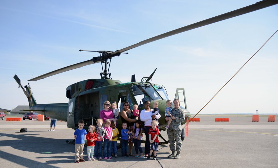 Team Malmstrom families pose in front of a UH-1N Huey during a static display April 22, 2015, at Malmstrom Air Force Base, Mont. Malmstrom Family Child Care, in conjunction with the 40th Helicopter Squadron, hosted the event to teach children more about the helicopter. (U.S. Air Force photo/Airman 1st Class Dillon Johnston)