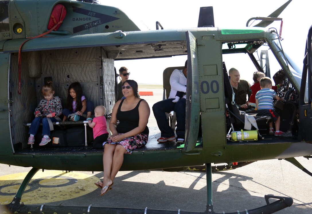 Team Malmstrom families explore a UH-1N Huey during a static display April 22, 2015, at Malmstrom Air Force Base, Mont. Malmstrom Family Child Care, in conjunction with the 40th Helicopter Squadron, hosted the event to teach children more about the helicopter. (U.S. Air Force photo/Airman 1st Class Dillon Johnston)