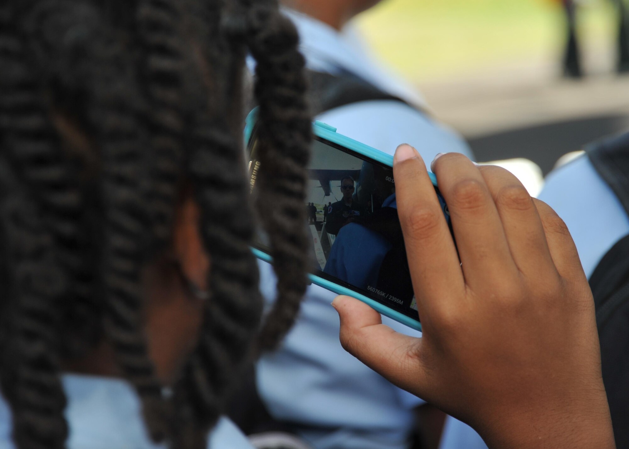 A student from St. Eustatius films Lt. Col. Matthew Muha, 53rd Weather Reconnaissance Squadron commander and navigator, as he briefs grade school students April 24, 2015, during the Caribbean Hurricane Awareness Tour. More than 500 students were informed how the Hurricane Hunters use the WC-130J to collect vital weather data for the National Hurricane Center in Miami, which improves their forecasts. About 50 students from Saba made an hour ferry ride to attend the event designed to promote hurricane awareness and preparedness in the Caribbean region. (U.S. Air Force photo/Maj. Marnee A.C. Losurdo)