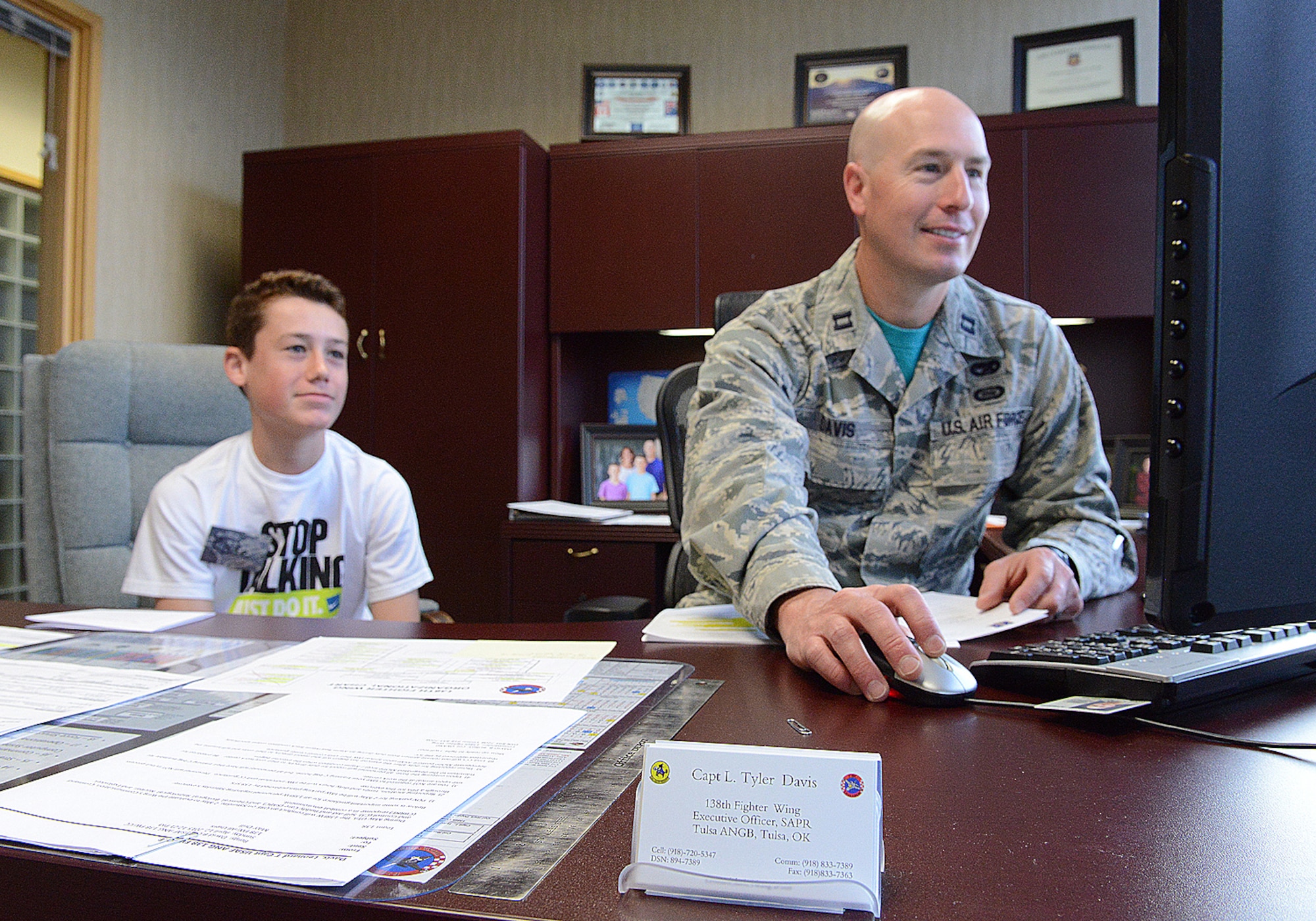 Kade Davis, son of Capt. Tyler Davis, 138th Fighter Wing Executive Officer, watches over his dad's shoulder as he works at the Tulsa Air National Guard Base, Okla., 23 April, 2015, during "National Take Our Daughters and Sons to Work Day.”   The 138th participated in the event as a way to give children an insight into what their parents do, as well as demonstrating to them what is involved day to day in a job or career.  (U.S. National Guard photo by Senior Master Sgt.  Preston L. Chasteen/Released)