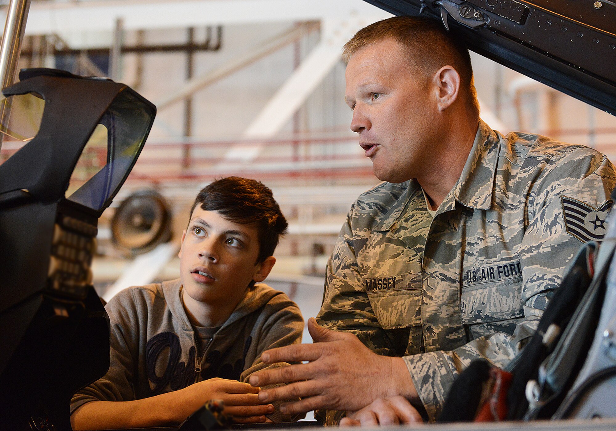 Tech. Sgt. Brian Massey, 138th Aircraft Maintenance Squadron, talks to John Hill Jr., son of Tech. Sgt. John Hill, 138th Contracting Office, about the capabilities of the F-16 at the Tulsa Air National Guard Base, Okla., 23 April, 2015, during "National Take Our Daughters and Sons to Work Day".   The 138th participated in the event as a way to give children an insight into what their parents do, as well as demonstrating to them what is involved day to day in a job or career.  (U.S. National Guard photo by Senior Master Sgt.  Preston L. Chasteen/Released)