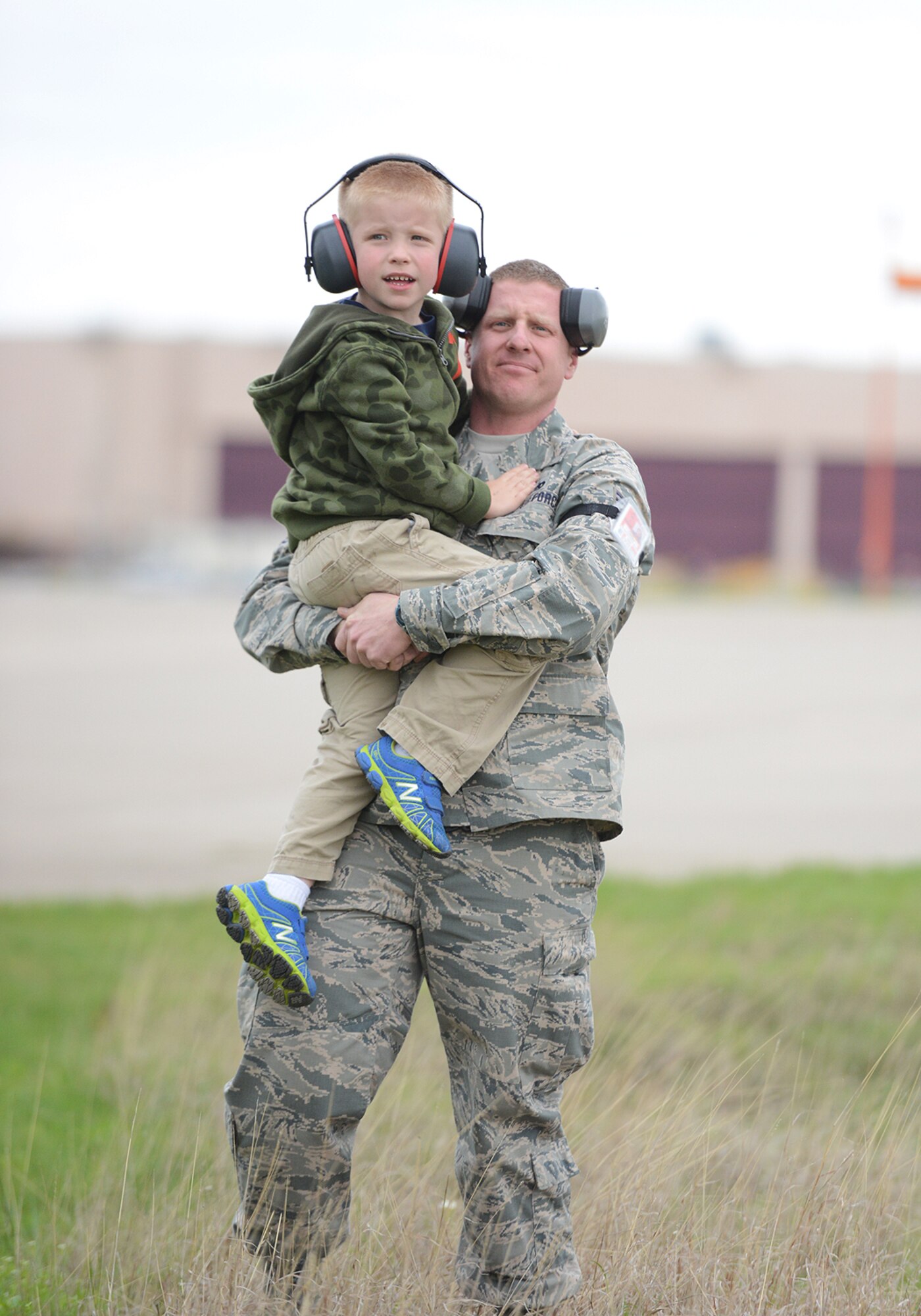 Tech. Sgt. Kevin Larson, 138th Logistics Readiness Squadron, holds his son Wyatt as they watch F-16's take-off at the Tulsa Air National Guard Base, Okla., during "National Take Our Daughters and Sons to Work Day".   The 138th participated in the event as a way to give children an insight into what their parents do, as well as demonstrating to them what is involved day to day in a job or career.  (U.S. National Guard photo by Senior Master Sgt.  Preston L. Chasteen/Released)   