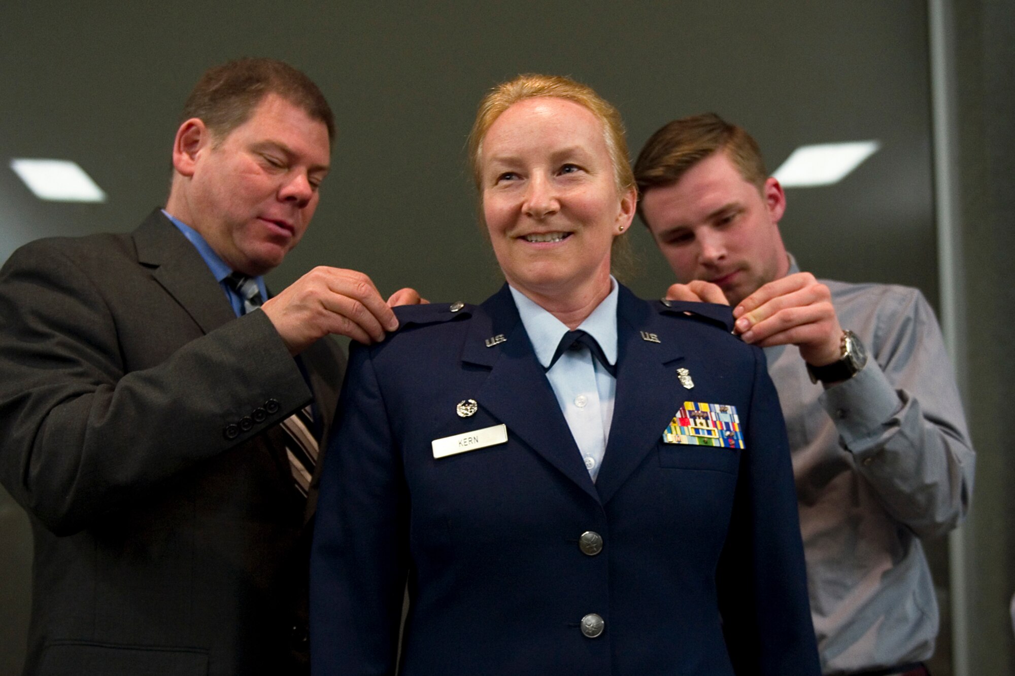 Col. Therese Kern, 434th Aerospace Medicine Squadron commander, has her husband, Joseph, left, and son, Joey, right, pin eagle rank insignias on her service dress coat during a pin-on ceremony at Grissom Air Reserve Base, Ind., April. 12, 2015. Kern came to Grissom July 2013, serving as chief nurse, and took over command of the  434th AMDS April 2014. (U.S. Air Force photo/Tech. Sgt. Benjamin Mota)
