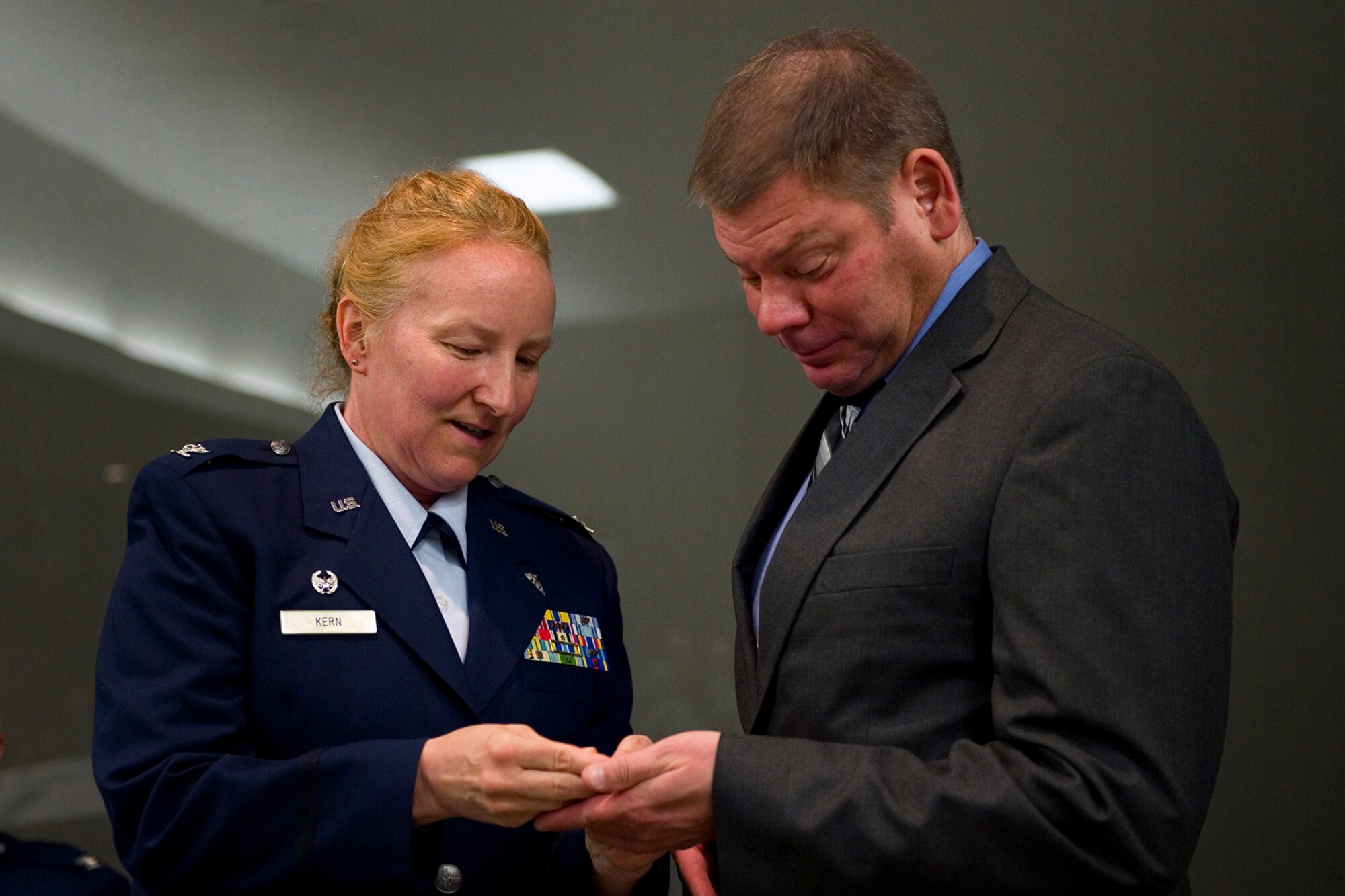 Col. Therese Kern, 434th Aerospace Medicine Squadron commander, gives her husband, Joseph, a colonel coin engraved "love you" during a pin-on ceremony at Grissom Air Reserve Base, Ind., April. 12, 2015. Kern, a Wisconsin native and board certified nurse practitioner, took over command of the 434th AMDS April 2014. (U.S. Air Force photo/Tech. Sgt. Benjamin Mota)