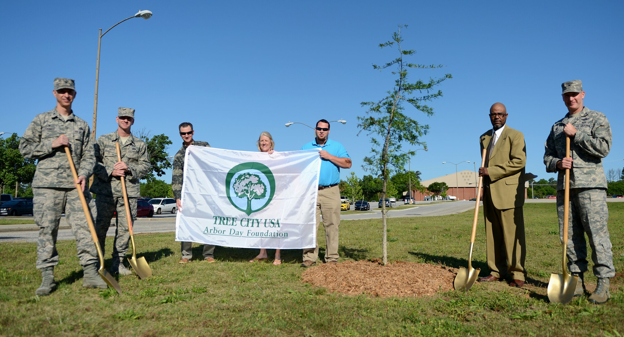 Members of the 20th Fighter Wing stand near a newly planted Bald Cyprus tree during an Arbor Day celebration at Shaw Air Force Base, S.C., April 22, 2015.  Shaw has been a member of Tree City USA since 1999, planting at least one tree each year. (U.S. Air Force photo by Senior Airman Jensen Stidham/Released)
