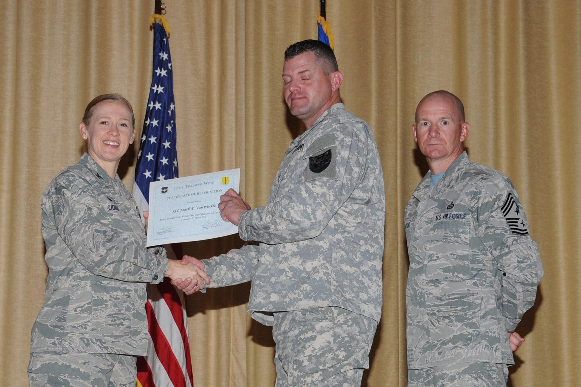 GOODFELLOW AIR FORCE BASE, Texas - Col. Kimberlee P. Joos, 17th Training Wing Commander, and Chief Master Sgt. Thomas F. Good, 17th TRW Command Chief, present the Team Goodfellow Senior Service Member of the Quarter award to Army Sgt. 1st Class Mark T. VanWinkle, 344th Military Intelligence Battalion, during the wing quarterly awards ceremony at the base theater April 24. (U.S. Air Force photo/ Staff Sgt. Laura R. McFarlane)