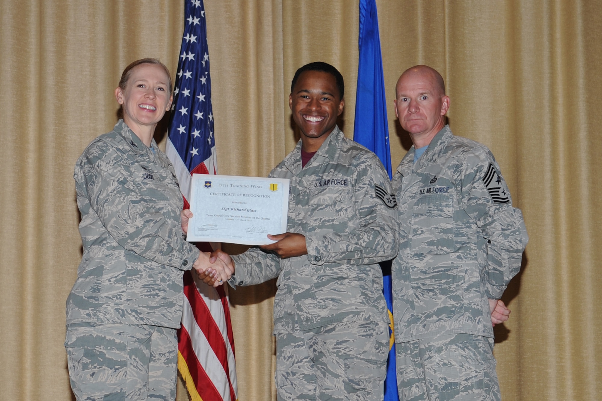 GOODFELLOW AIR FORCE BASE, Texas - Col. Kimberlee P. Joos, 17th Training Wing Commander, and Chief Master Sgt. Thomas F. Good, 17th TRW Command Chief, present the Team Goodfellow Service Member of the Quarter award to Staff Sgt. Richard Glass, 17th Medical Group, during the wing quarterly awards ceremony at the base theater April 24. Glass also received the 17th TRW NCO of the Quarter (U.S. Air Force photo/ Staff Sgt. Laura R. McFarlane)