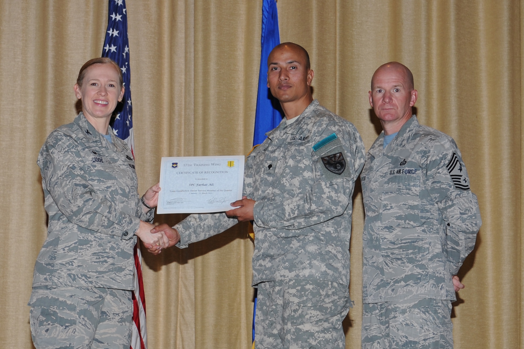 GOODFELLOW AIR FORCE BASE, Texas - Col. Kimberlee P. Joos, 17th Training Wing Commander, and Chief Master Sgt. Thomas F. Good, 17th TRW Command Chief, present the Team Goodfellow Junior Service Member of the Quarter award to Army Spc. Farhat Ali, 344th Military Intelligence Battalion, during the wing quarterly awards ceremony at the base theater April 24. (U.S. Air Force photo/ Staff Sgt. Laura R. McFarlane)