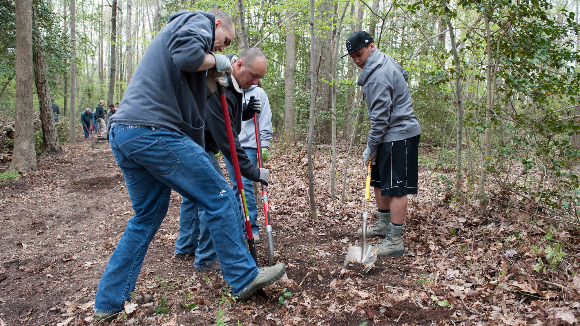 Senior Airman Brady O’Neill, 436th Comptroller Squadron financial analyst, left, Dan Tavares, husband of Senior Airman Tiffany Tavares, 436th CPTS financial technician, center, and Senior Airman Stanley Wilson, 436th CPTS financial technician, remove a tree stump during a trail blazing and reforestation event April 25, 2015, at Browns Branch County Park in Harrington, Del. Team Dover volunteers helped clear a three quarters of a mile trail. (U.S. Air Force photo/Airman 1st Class Zachary Cacicia)