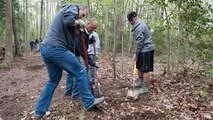 Senior Airman Brady O’Neill, 436th Comptroller Squadron financial analyst, left, Dan Tavares, husband of Senior Airman Tiffany Tavares, 436th CPTS financial technician, center, and Senior Airman Stanley Wilson, 436th CPTS financial technician, remove a tree stump during a trail blazing and reforestation event April 25, 2015, at Browns Branch County Park in Harrington, Del. Team Dover volunteers helped clear a three quarters of a mile trail. (U.S. Air Force photo/Airman 1st Class Zachary Cacicia)