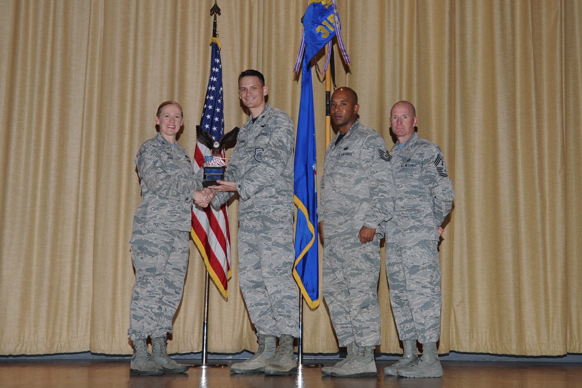 GOODFELLOW AIR FORCE BASE, Texas - Col. Kimberlee P. Joos, 17th Training Wing Commander, and Chief Master Sgt. Thomas F. Good, 17th TRW Command Chief, present the 17th Training Wing Unit of the Quarter award to Maj. Charles D. Laubach, 315th Training Squadron director of operations, during the wing quarterly awards ceremony at the base theater April 24. The 315th TRS also received the Team Goodfellow Unit of the Quarter. (U.S. Air Force photo/Staff Sgt. Laura R. McFarlane)