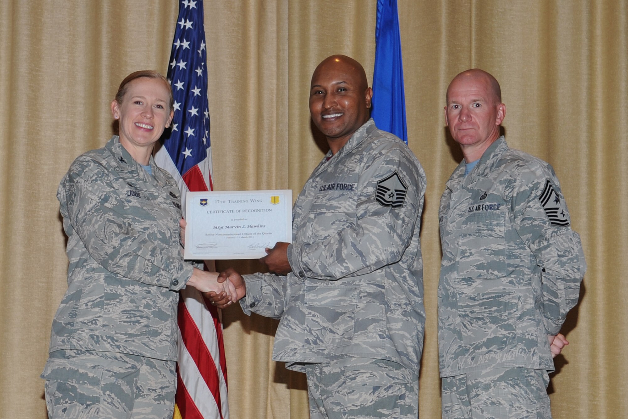 GOODFELLOW AIR FORCE BASE, Texas - Col. Kimberlee P. Joos, 17th Training Wing Commander, and Chief Master Sgt. Thomas F. Good, 17th TRW Command Chief, present the 17th Training Wing Senior NCO of the Quarter award to Master Sgt. Marvin L. Hawkins, 17th Medical Group, during the wing quarterly awards ceremony at the base theater April 24. (U.S. Air Force photo/Staff Sgt. Laura R. McFarlane)