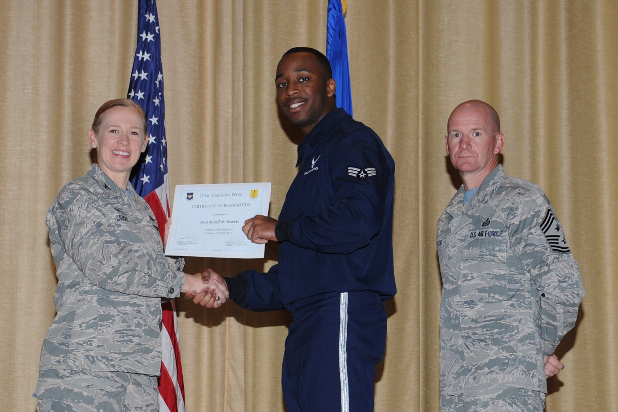GOODFELLOW AIR FORCE BASE, Texas - Col. Kimberlee P. Joos, 17th Training Wing Commander, and Chief Master Sgt. Thomas F. Good, 17th TRW Command Chief, present the Airman of the Quarter award to Senior Airman Terell R. Harris, 17th Medical Group, during the wing quarterly awards ceremony at the base theater April 24. (U.S. Air Force photo/ Staff Sgt. Laura R. McFarlane)